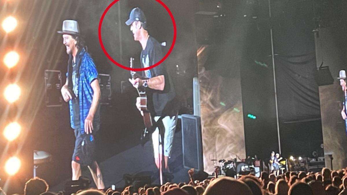 Iconic rock frontman calls AFL legend on stage during show