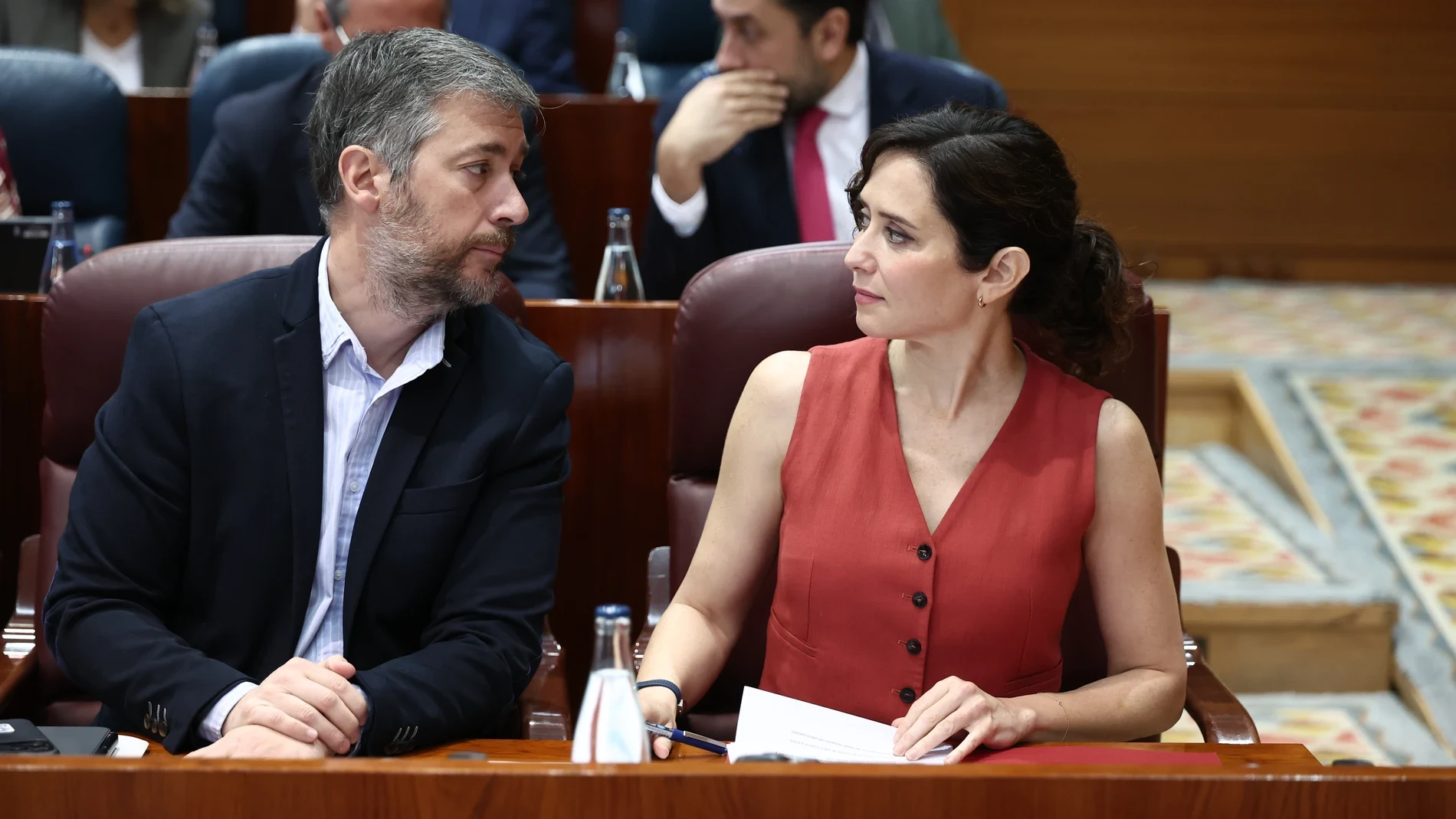 Isabel Díaz Ayuso rompe el uniforme político con el look más poderoso: chaleco rojo, bermudas de piel y botas altas