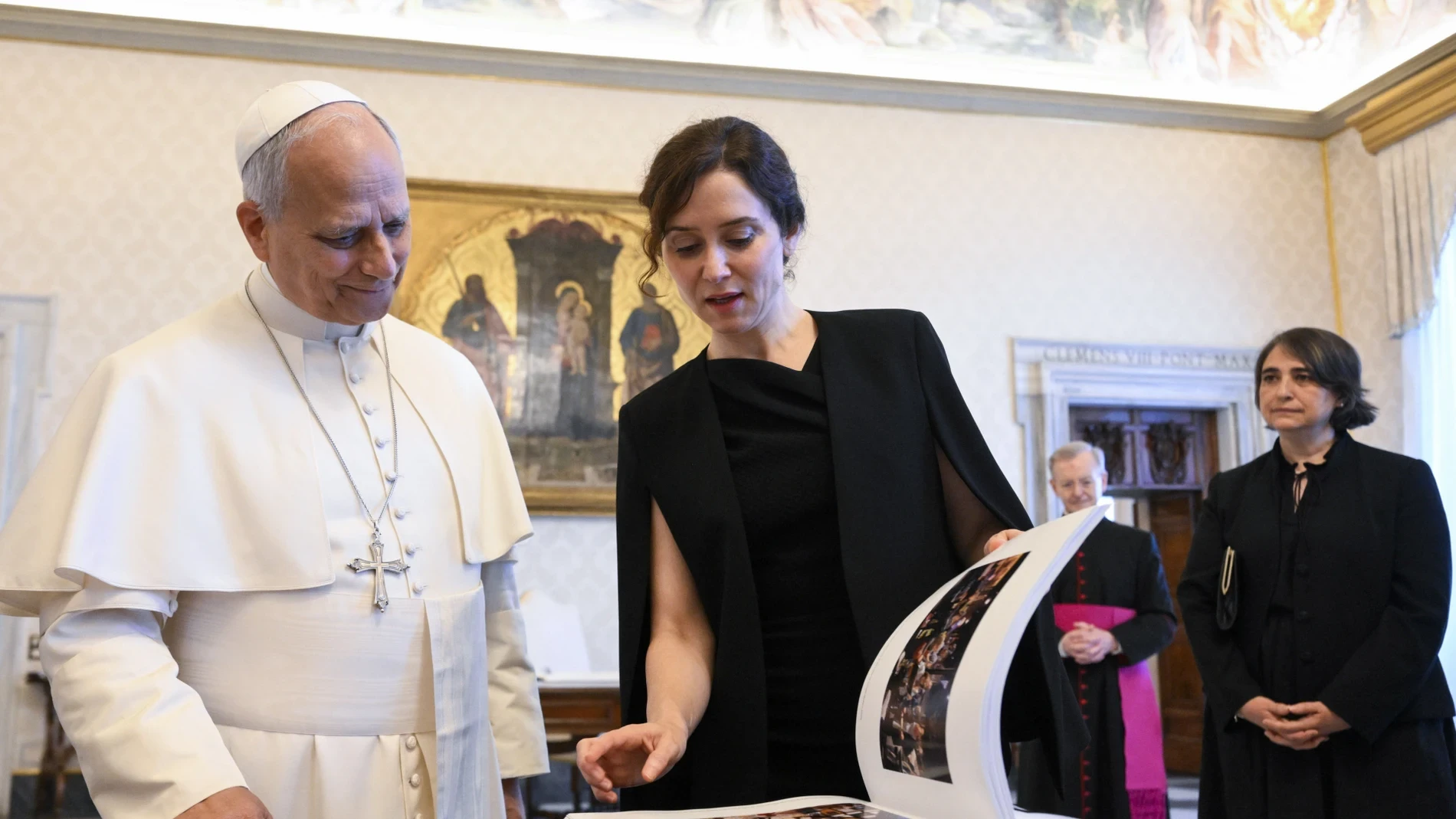 Ayuso viaja al Vaticano con el look más solemne y elegante de su armario: vestido negro asimétrico y blazer capa para reunirse con el Papa León XIV