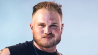 Watch the moment Zach Bryan falls off golf cart after crash as pal does a wheelie while backstage at New Orleans concert