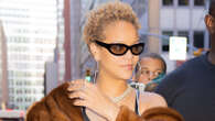 Rihanna covers her stomach with purse and wears massive coat during NYC outings as fans suspect singer is pregnant