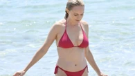 90s movie pin-up, 55, has barely aged a day as she strips down to tiny bikini 26 years after iconic role
