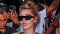 Miley Cyrus goes braless under totally see-through black dress as she signs autographs outside NYC hotel
