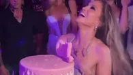 J-Lo goes braless as she stuns in plunging silver dress and dances around huge cake to celebrate 56th birthday