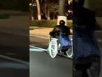 Two elderly men race in their electric wheelchairs