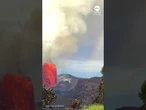 Erupting volcano and rainbow share sky in Hawaii