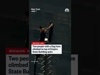 Two people climb the Empire State Building spire