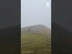 Man struggles to stay upright as powerful winds hit France