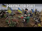 Ukrainians prayed for peace yesterday as a vast military cemetery laid bare the stage