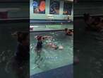 Instructor throws baby in pool for swim lesson