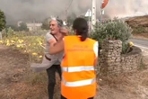Una mujer desgarrada mientras es obligada a abandonar su casa por los incendios