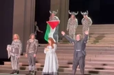 Un artista despliega una bandera palestina en el escenario de la Royal Opera House de Londres
