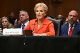 Wrestler Triple H sits behind Linda McMahon at her Senate hearing