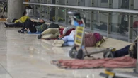 Las personas sin techo se trasladan al parking de la T-4 por los controles de acceso en Barajas
