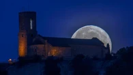La luna llena de fresa 'atraviesa' la iglesia Sant Andreu en el montículo del Castell de Tona
