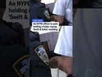 An NYPD officer is seen holding a folder saying 'Swift & Kelce' wedding