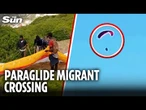 Shocking moment migrant PARAGLIDES over heavily-fortified border fence as he sneaks into Spain