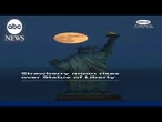 Strawberry moon rises over Statue of Liberty