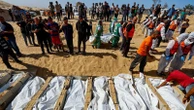 Mass funeral in Gaza as signs of alleged abuse reported on bodies returned by Israel