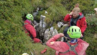 Rescuers work to free an injured cave explorer trapped more than 130 feet underground in Italy