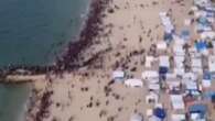 Aiuti paracadutati su Gaza, migliaia di sfollati si radunano sulla spiaggia