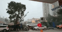 Hà Nội mưa dông mạnh, gió thổi bạt người đi xe máy, trời tối sầm rồi mưa như trút