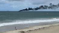 breakingBoat on fire off Cottesloe, two men aboard in rescue dinghy