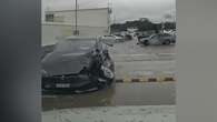 Out-of-control Tesla crashes into cars, plunges off carpark roof