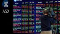 Aussie shares flat as banks drag, BHP, Woodside gain