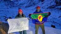 Couple from northwestern Ontario wave their First Nations' flags at Mount Everest's base camp