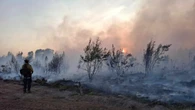 Out-of-control wildfires burn on, with slight relief from heat expected Thursday