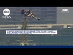 Two people climb to the top of Empire State Building spire, unfurl banner