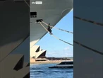 Man attempts to board ship via mooring ropes