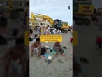 Sulla spiaggia di Osta, affollata di bagnanti, spunta una gru