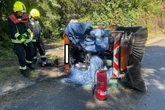 Kehrmaschine kippt um: Feuerwehr befreit Fahrer