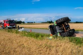 Traktor stürzt um: Fahrerin kann sich selbst retten, wird aber verletzt