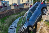 Renault durchbricht Geländer und bleibt senkrecht an Kanalmauer liegen