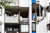 Heftige Explosion reißt Teil von Hausfassade auf, Trümmer krachen auf Gehweg und Kinderspielplatz
