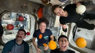 ISS astronauts pose with fresh fruit in microgravity