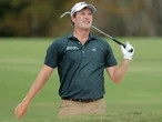 Golfer Vince Whaley hits shot with alligator behind him
