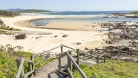 Teenage boy mauled by shark at popular beach as he's rushed to hospital