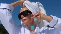 Victoria Beckham shows off tanned legs as she sprawls out in a white robe