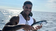 Rashford beams as he enjoys Barcelona downtime with a spot of fishing on yacht