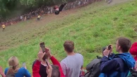 Moment daredevil SOMERSAULTS down hill in pursuit of 7lb wheel of cheese