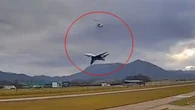 Moment plane comes terrifyingly close to helicopter as it takes off at airport
