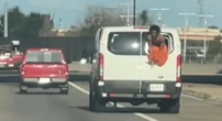 Shock moment shirtless prisoner hangs out back of van after smashing way out
