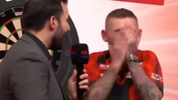 Darts host apologises as Aspinall covers face in horror during interview