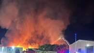 Huge fire rips through warehouses as residents hear 'loud bangs'