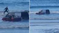 Moment van gets submerged by incoming tide after getting stuck on the beach