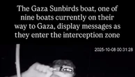 Flotilla, i cartelli per Gaza mostrati da un attivista prima dell'arrivo della marina israeliana